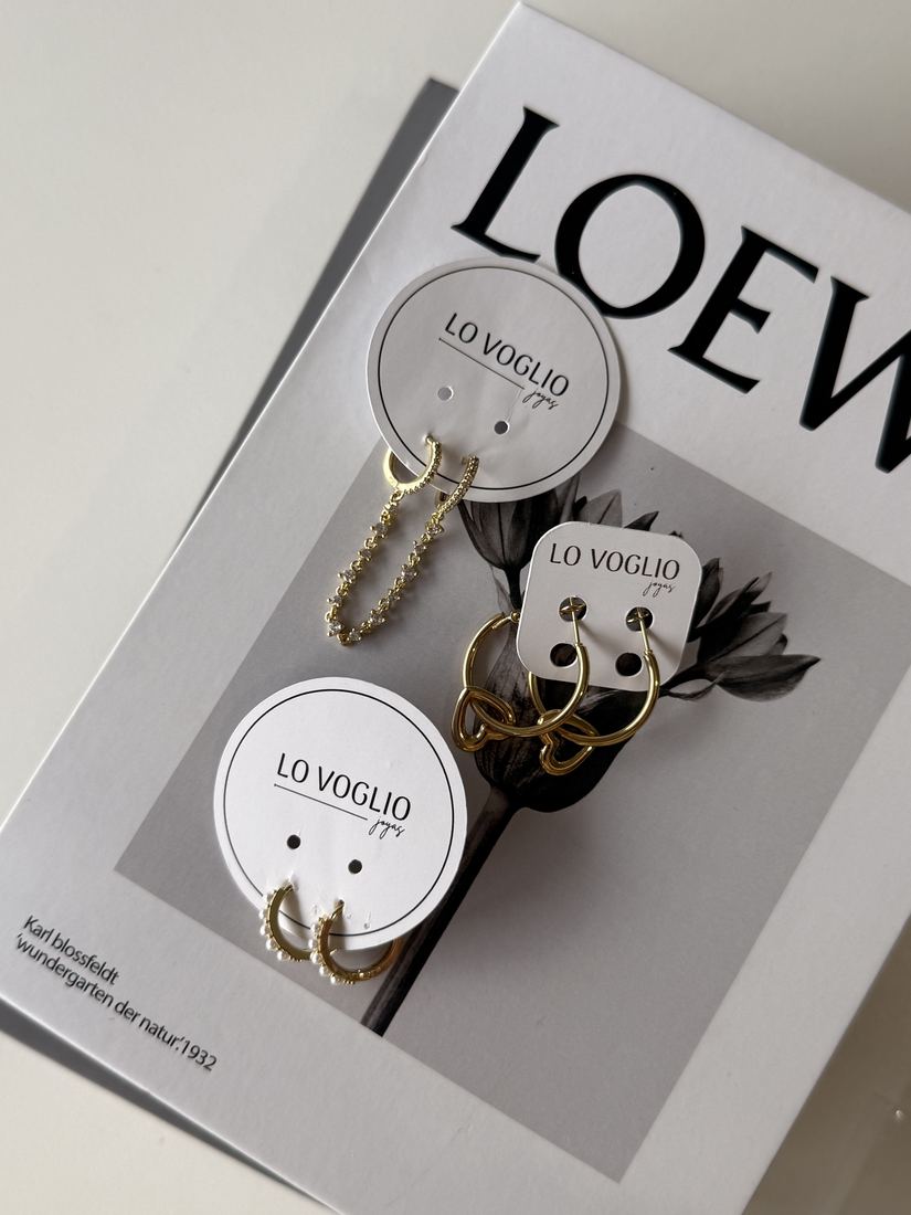 Aros dorados y plateados dispuestos sobre una revista de moda.